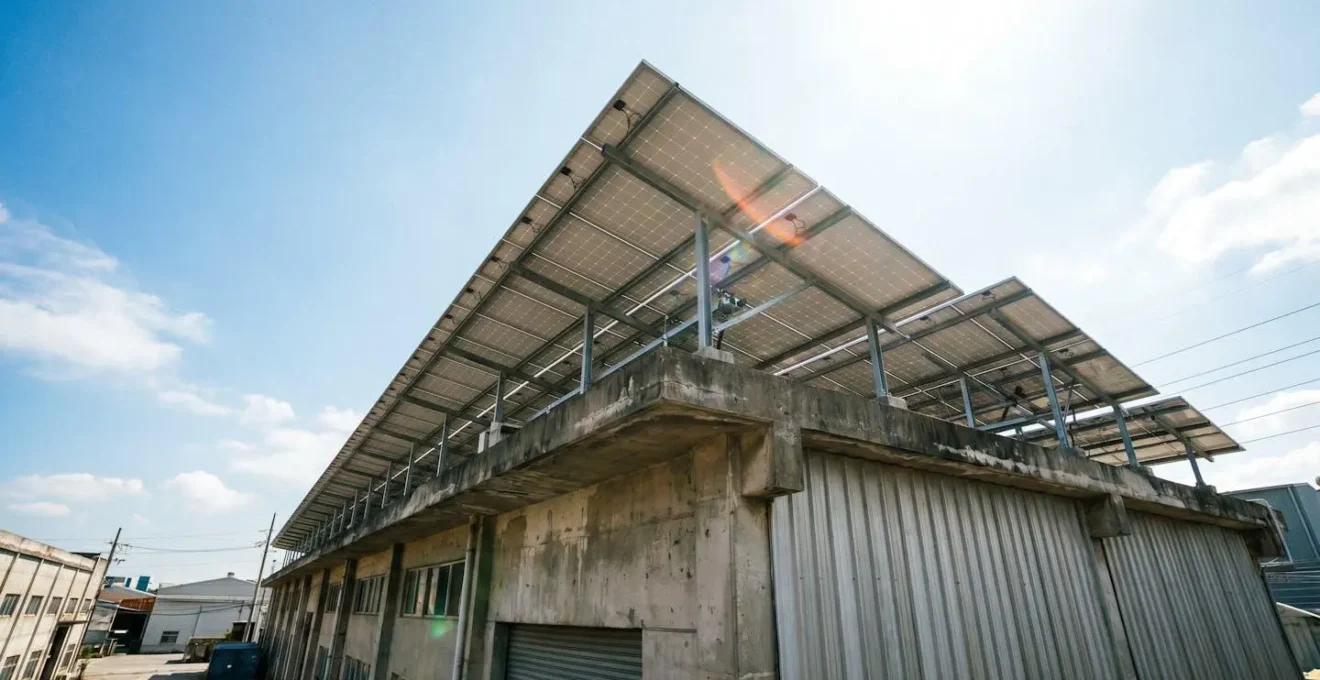 Vue en contre-plongée de panneaux solaires installés sur le toit plat d'un bâtiment commercial avec ciel bleu en arrière-plan
